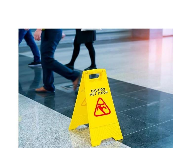 Business professionals walking on clean commercial building floor with a "caution wet floor sign".